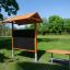Outdoor Classroom fa padokkal, napellenzővel és tábla, növénycserepek nélkül, kültéri környezetben.