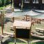 Outdoor Classroom fa padokkal, napernyőkkel és fekete táblával felszerelve kültéri tanuláshoz.