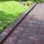 Rubber Tiles 55 barna gumilapok játszótéri járdához és zöld növényzethez.